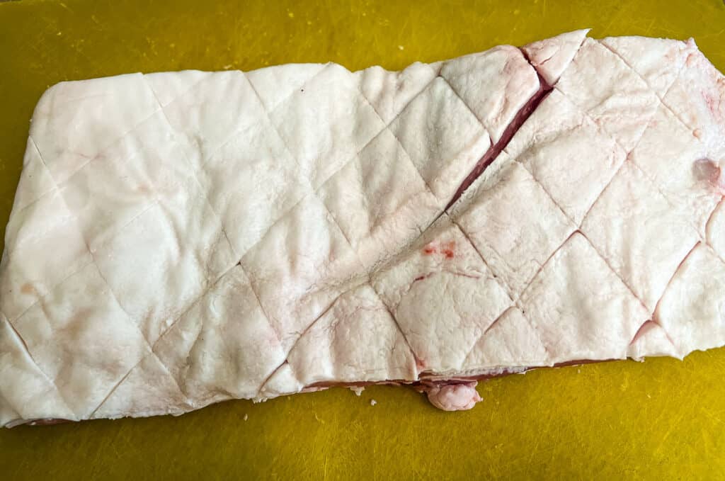 A 3 pound piece of pork belly scored.