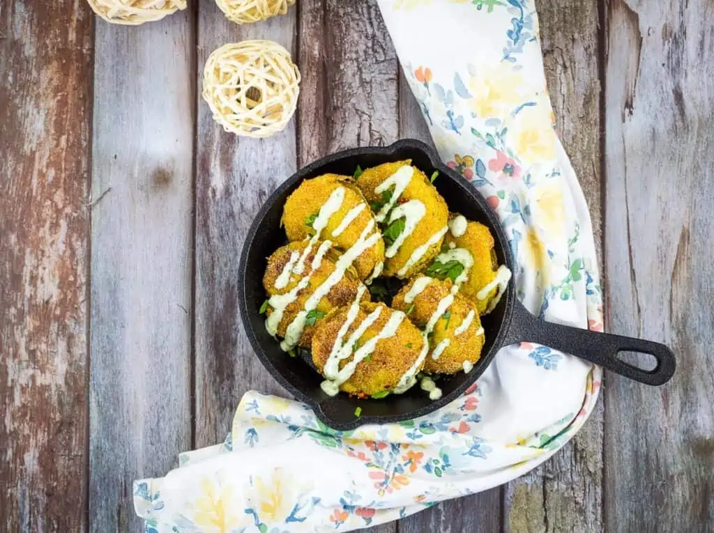 A top-down view of golden Fried Tomatillos in a black skillet.