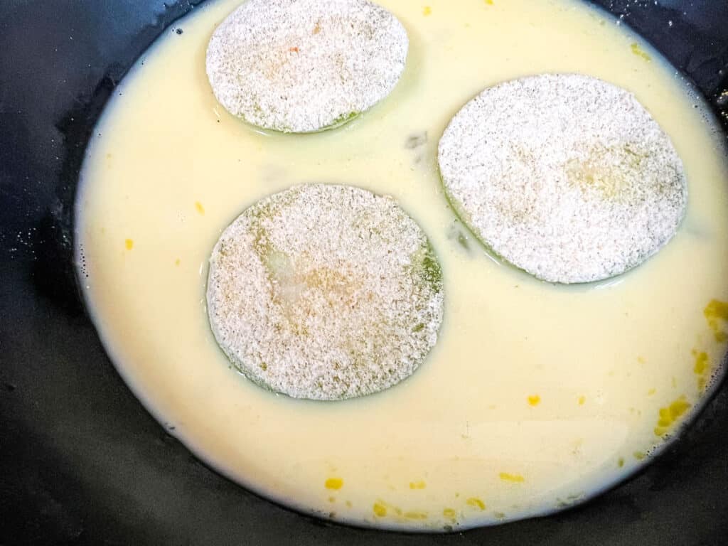 Floured tomatillos in egg wash.
