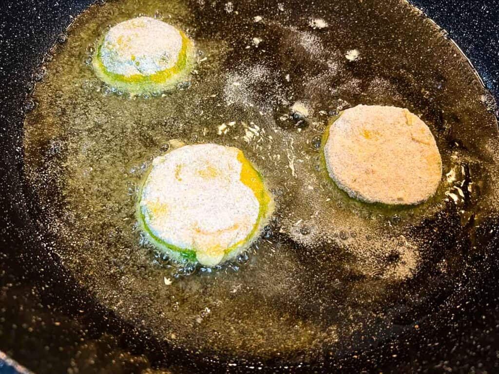 Shallow frying the battered tomatillos in oil.