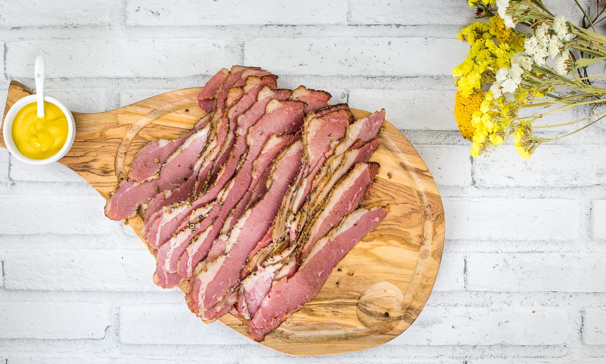 A top down shot of sliced Montreal Smoked Meat on a cutting board.