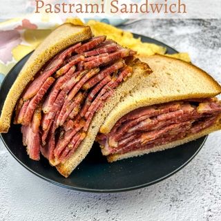 Pastrami Sandwich on a black plate.