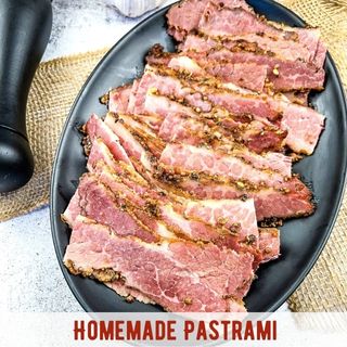 Sliced pastrami on a black plate.