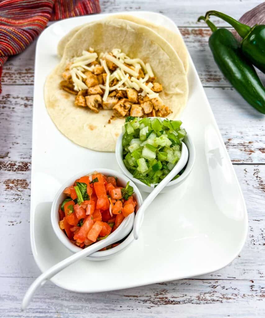 Pico de gallo on a plate with tacos.