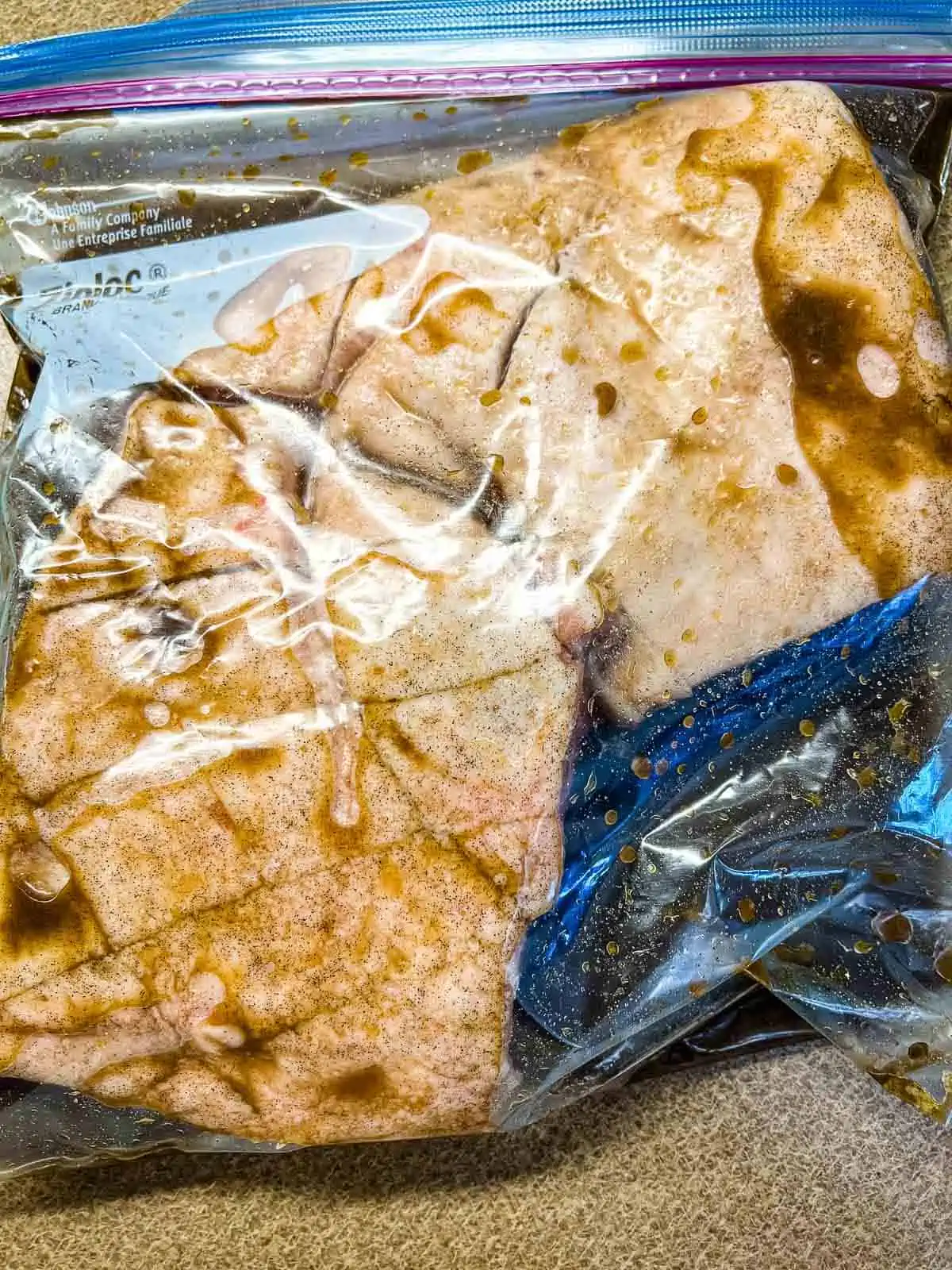 Pork belly in the brine inside a plastic bag.