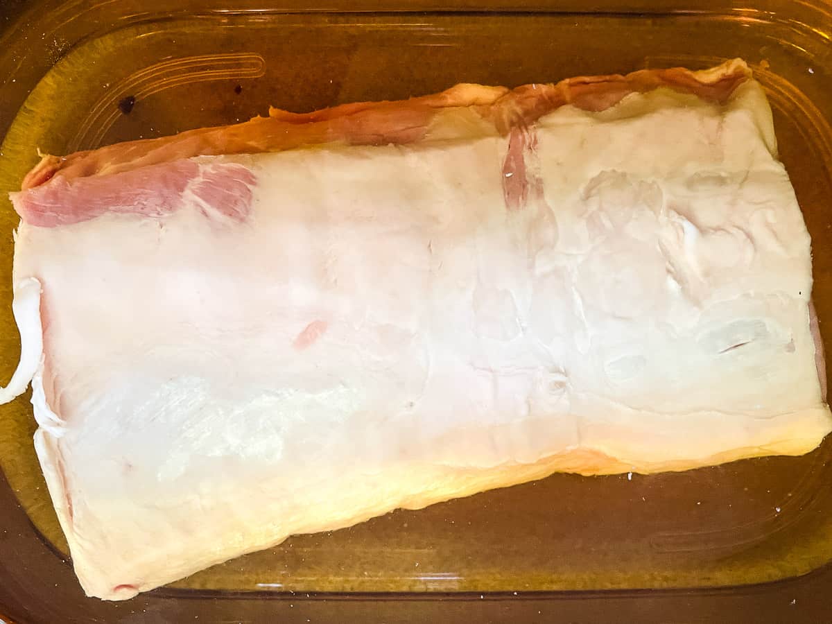 Raw pork loin in the brine in the fridge.