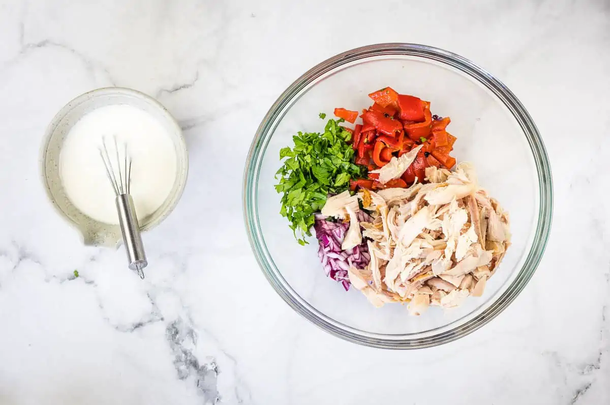 Prepped ingredients on a plate with the dressing next to it.