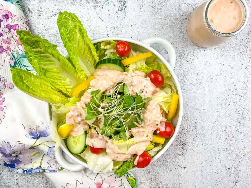 Salad in a bowl with dressing on it.