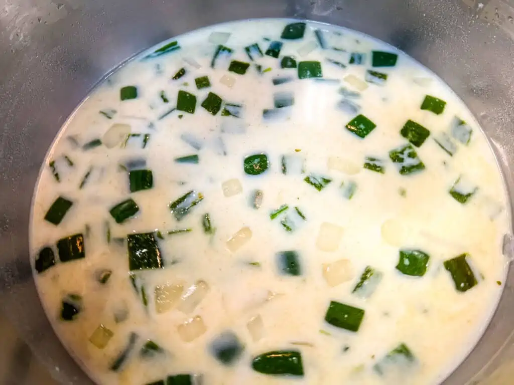 Simmering the soup with broth and milk.