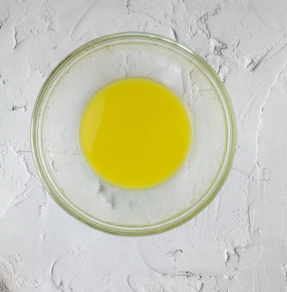 Lime juice and olive oil whisked in a bowl.