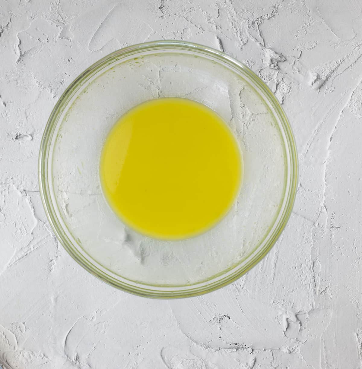 Lime juice and olive oil whisked in a bowl.
