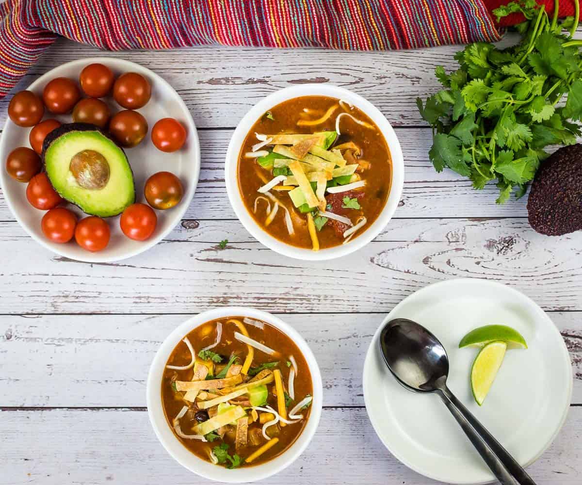 Finished Smoked Chicken Tortilla Soup in two bowls with garnishes.