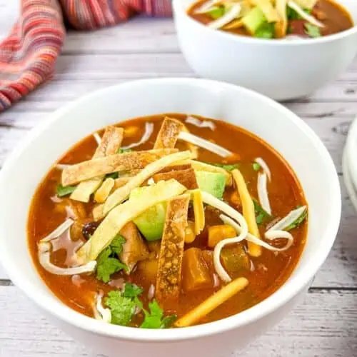 A closeup of Smoked Chicken Tortilla Soup in two bowls.