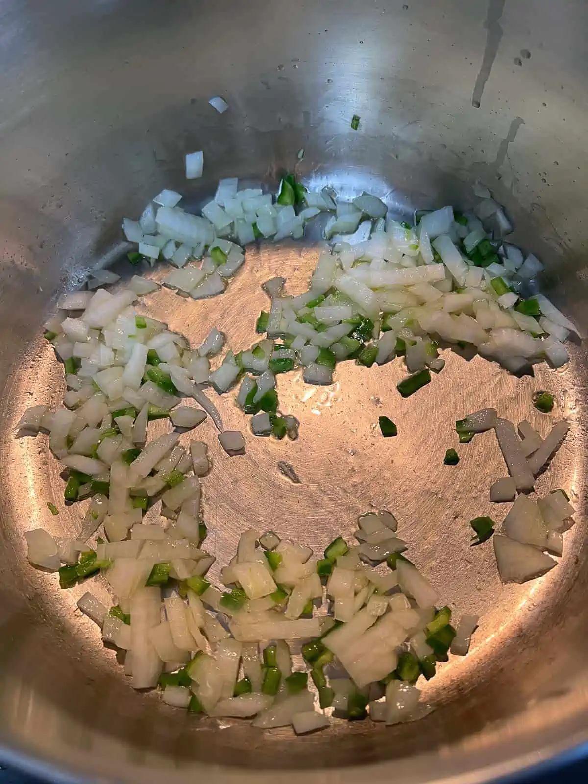 Onions and jalapeno cooking in a pot.