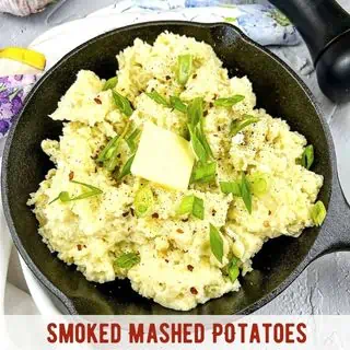 Smoked mashed potatoes in a black cast iron skillet.
