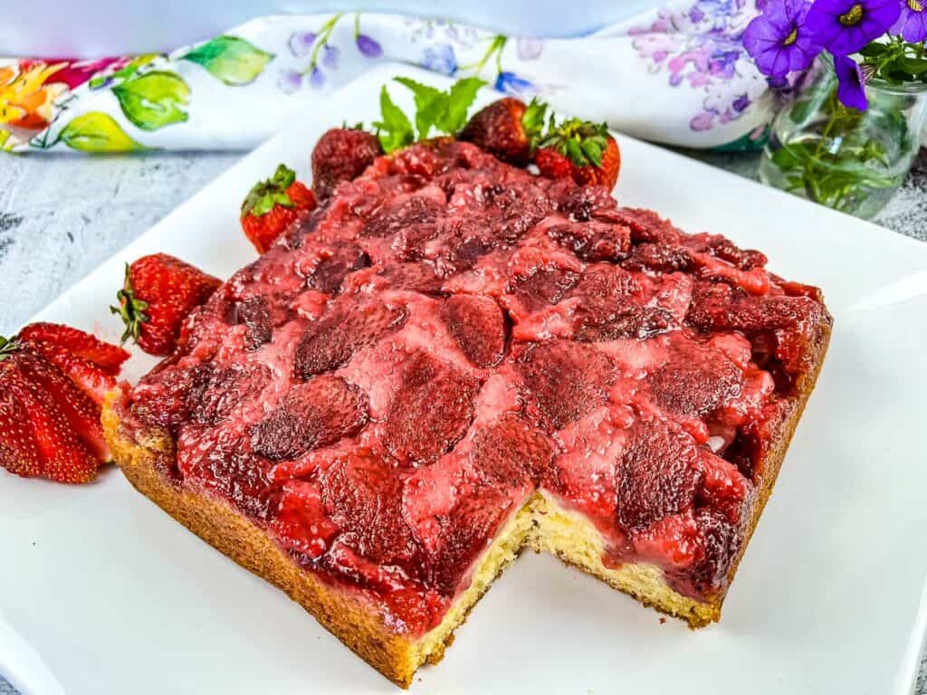 Finished Strawberry Upside Down Cake with a slice cut out of it.