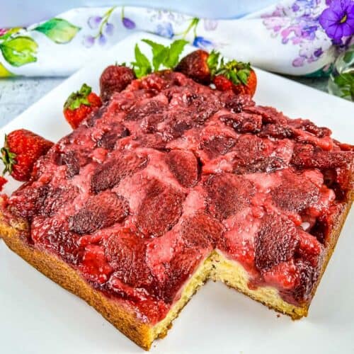 Finished Strawberry Upside Down Cake with a slice cut out of it.