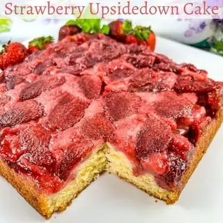 Strawberry upside down cake with a slice cut out of it.