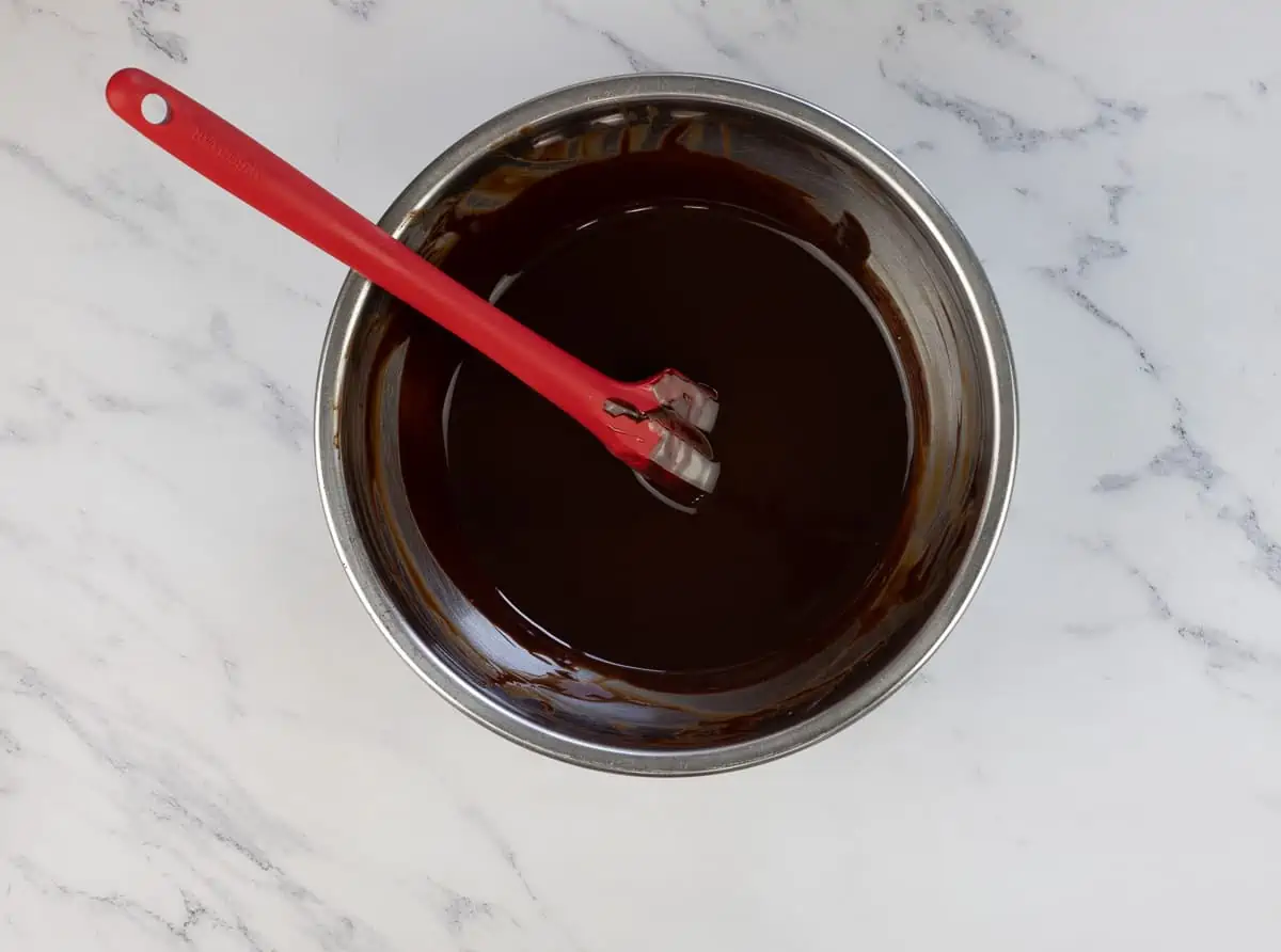 Melted chocolate in a bowl with a spatula.