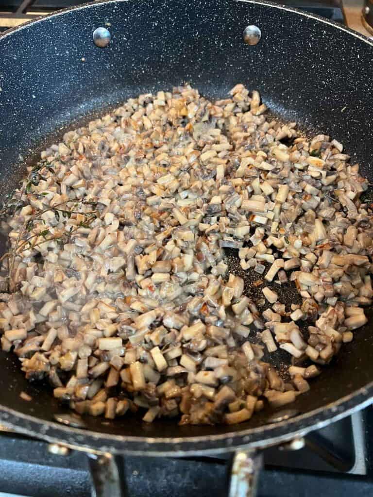 Sauted mushrooms with cream in a skillet.