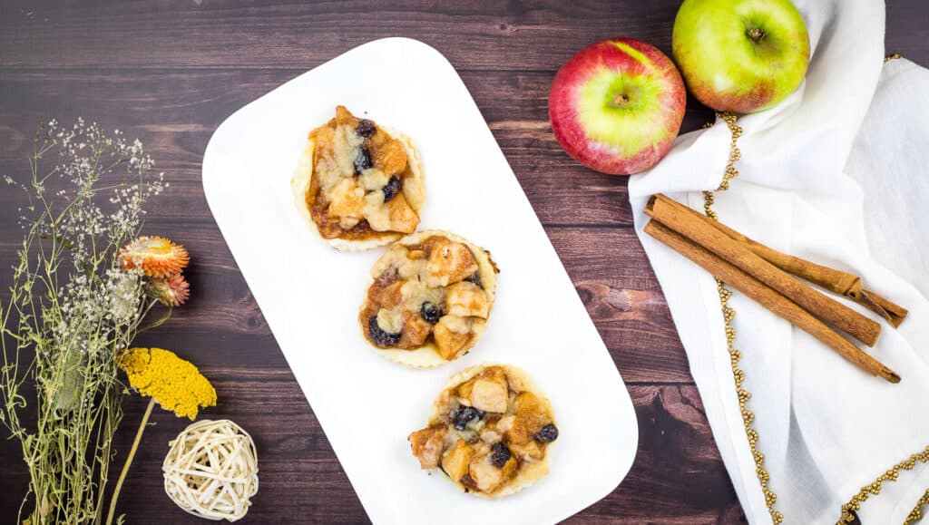Apple-cranberry puff pastry tarts on a white plate.