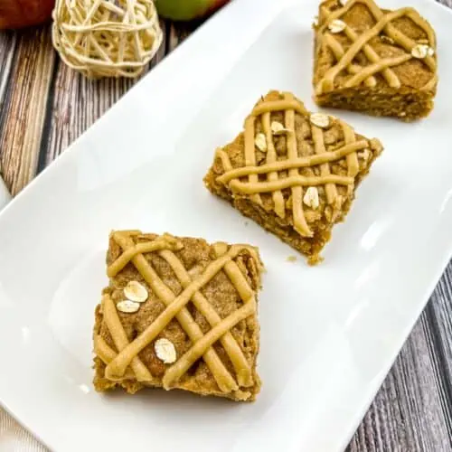 3 Brown butter apple blondies cut and on a white platter.
