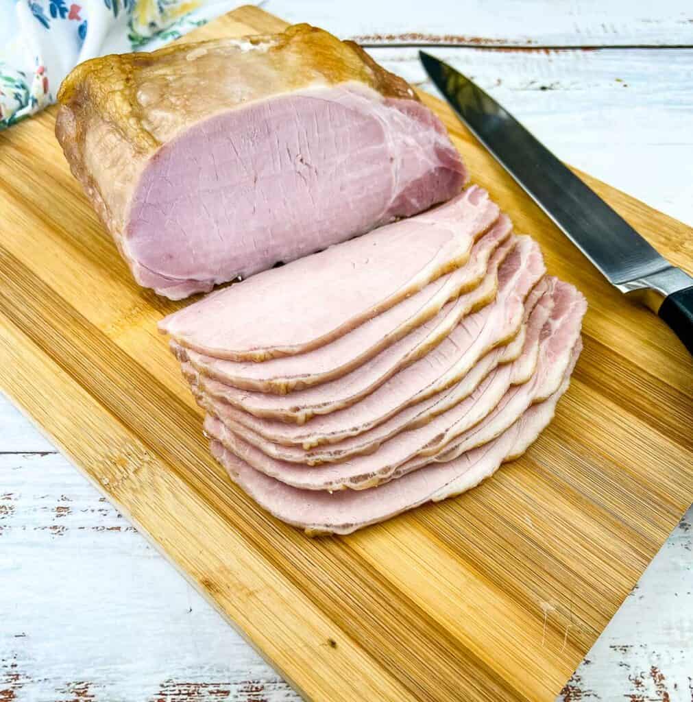 Sliced homemade back bacon on a cutting board.