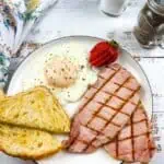 Homemade back bacon on a plate with eggs and toast.