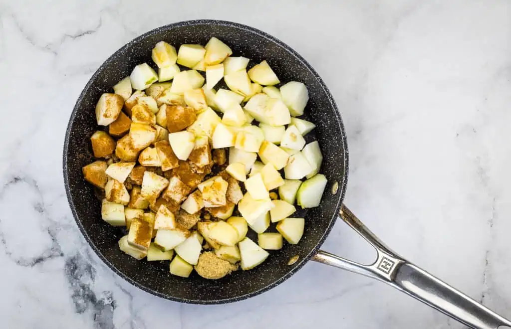 Cooking the apples, butter, and sugar in a skillet.