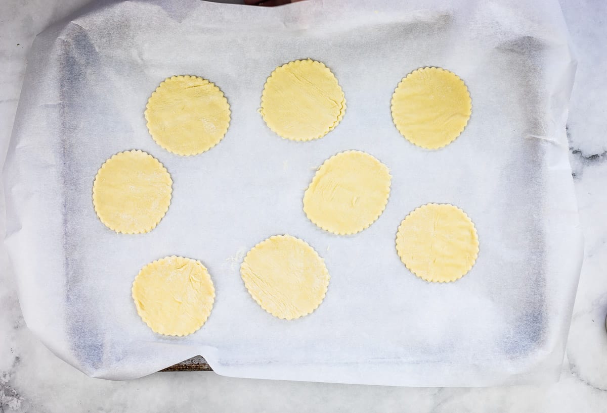 Cut out puff pastry rounds on a parchment paper lined baking sheet.