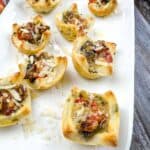 Bacon and mushroom tartlets on a white platter.
