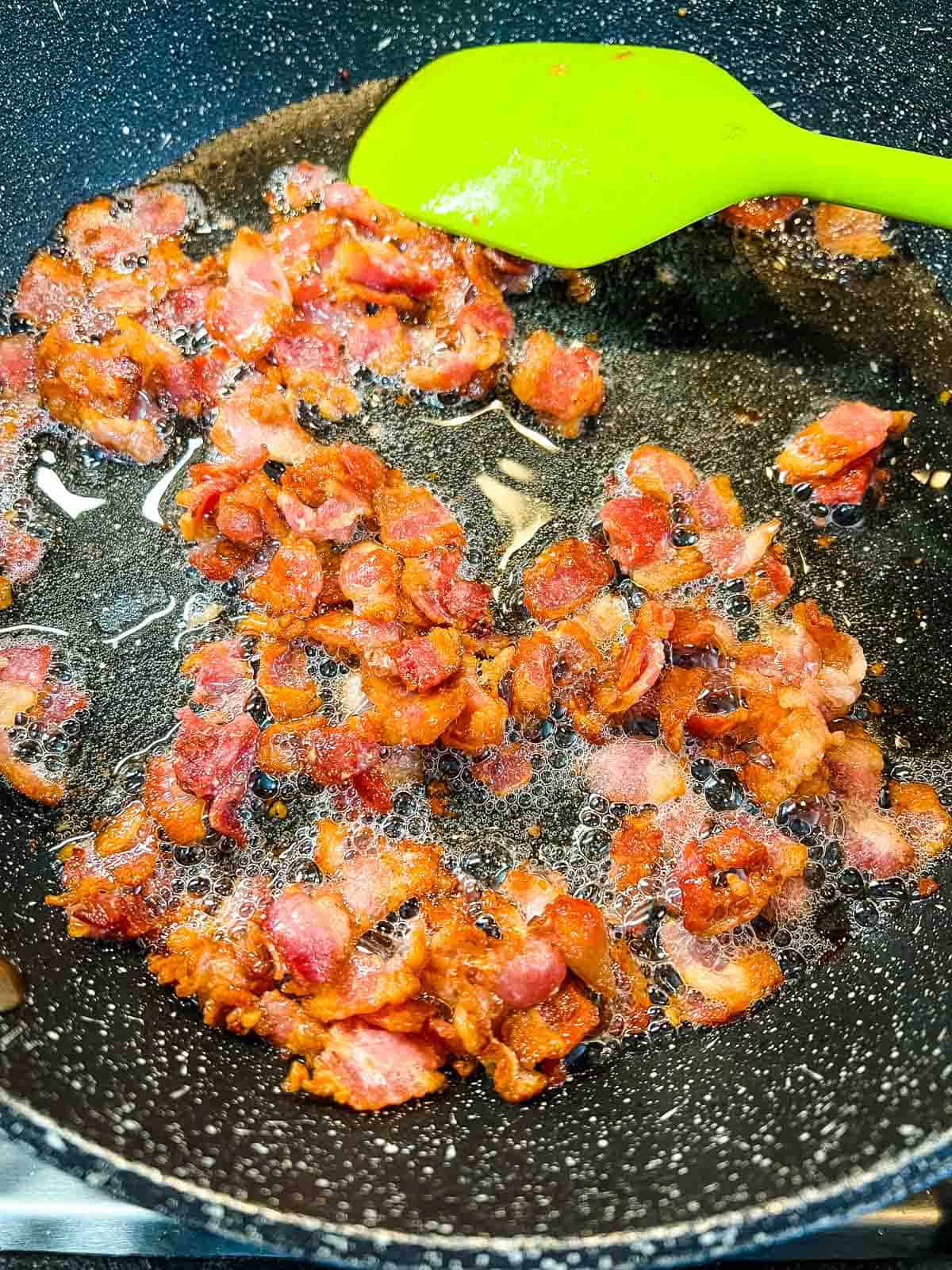 Frying bacon in a large skillet.