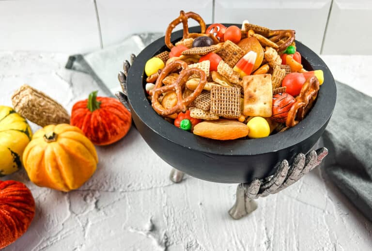 A bowl filled with candy, pretzels, and spicy Chex Mix.