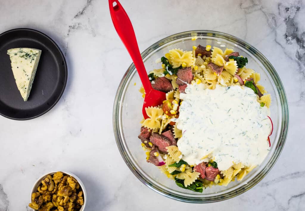 Dressing added to bowl of ingredients.