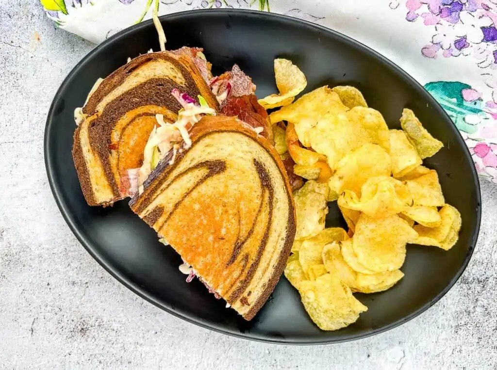 A top-down shot of a Rachel Sandwich on a black plate.