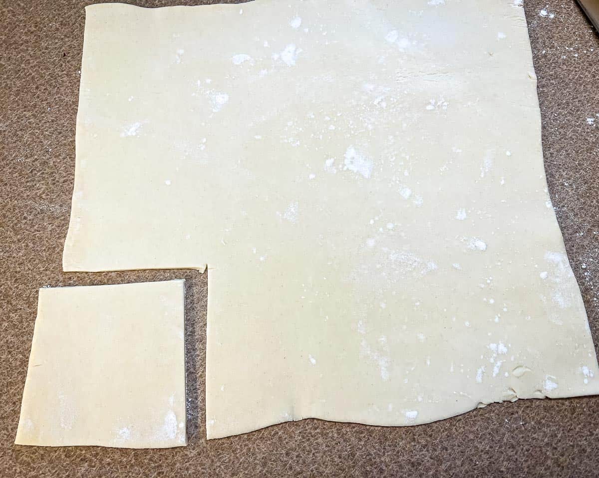 Rolled puff pastry with a square cut out of it.