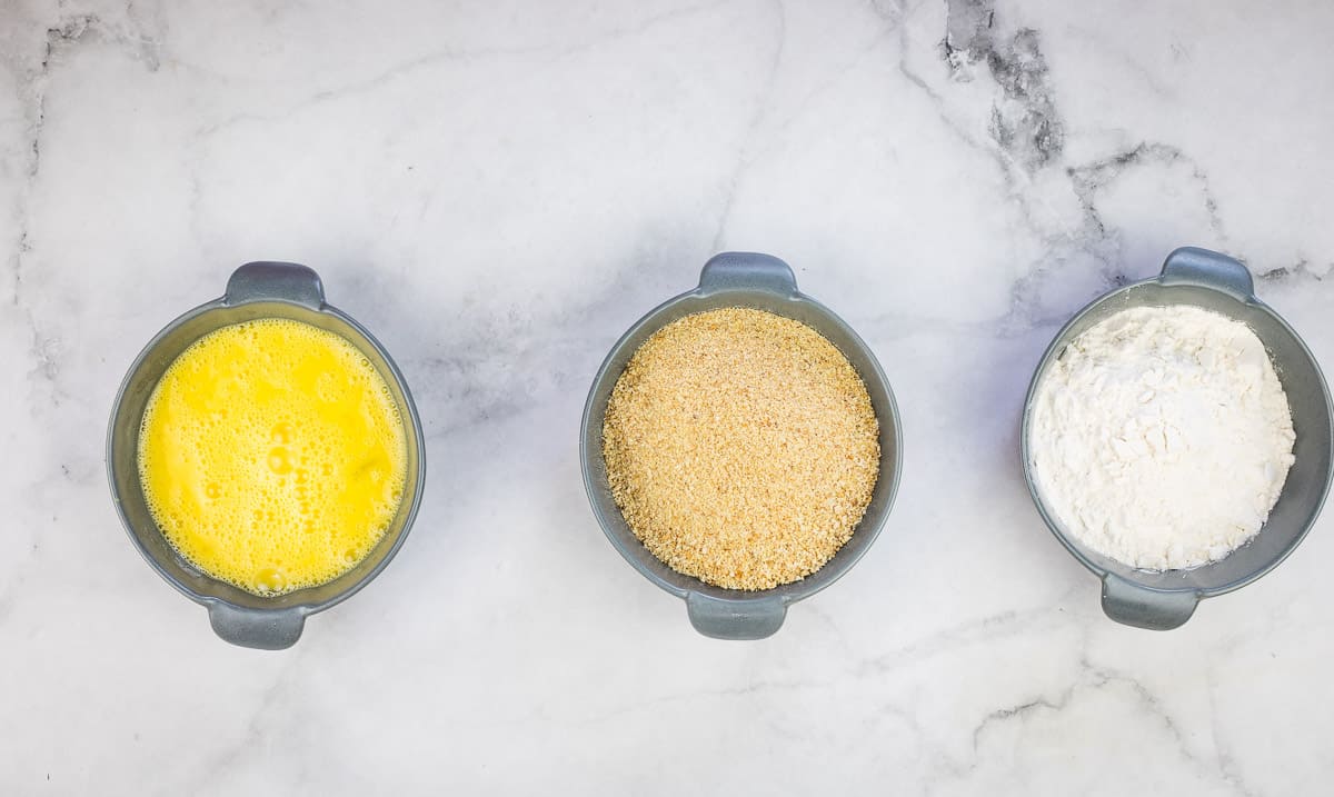 Flour, egg, and breadcrumbs in separate bowls. 
