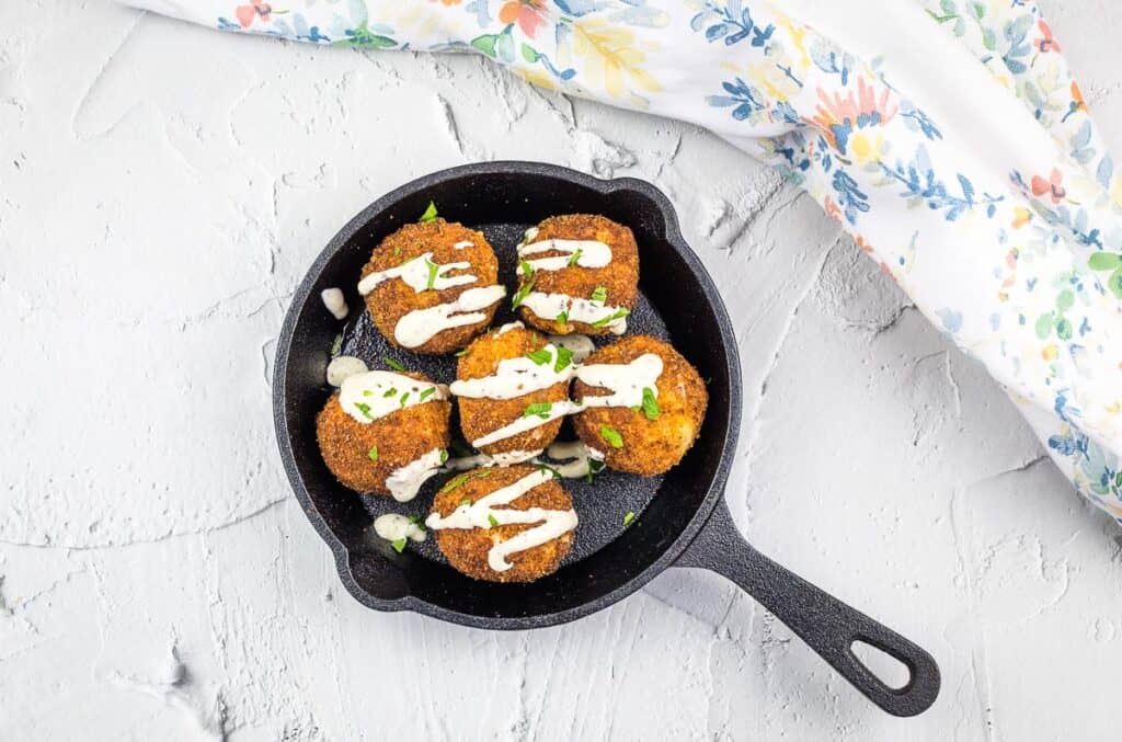 Sauerkraut balls in a black dish.