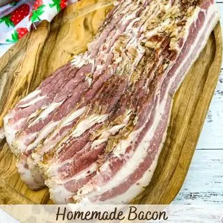 Sliced homemade bacon on a cutting board.