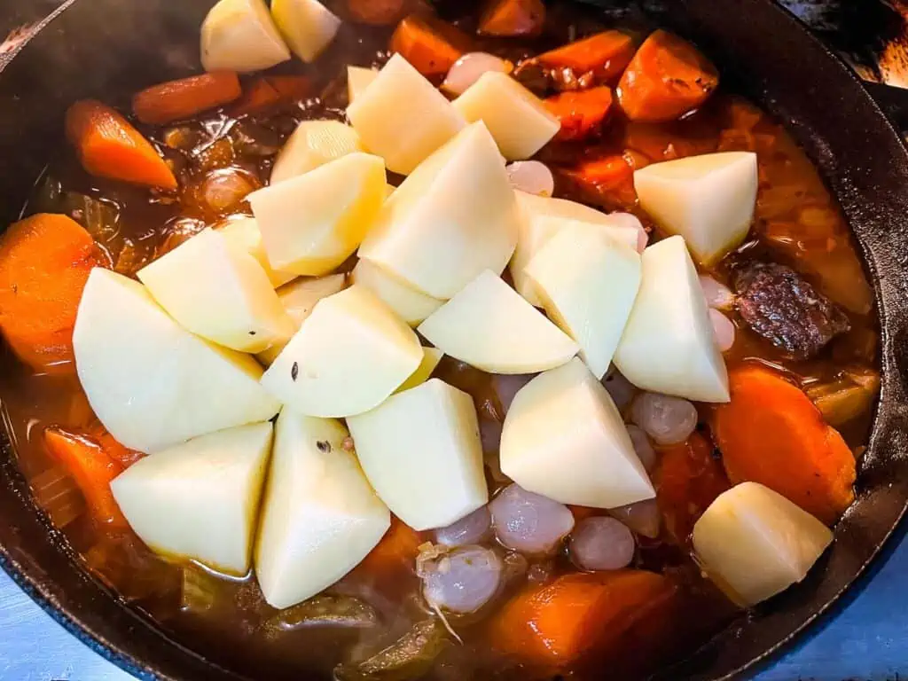 Potatoes and carrots added to stew.