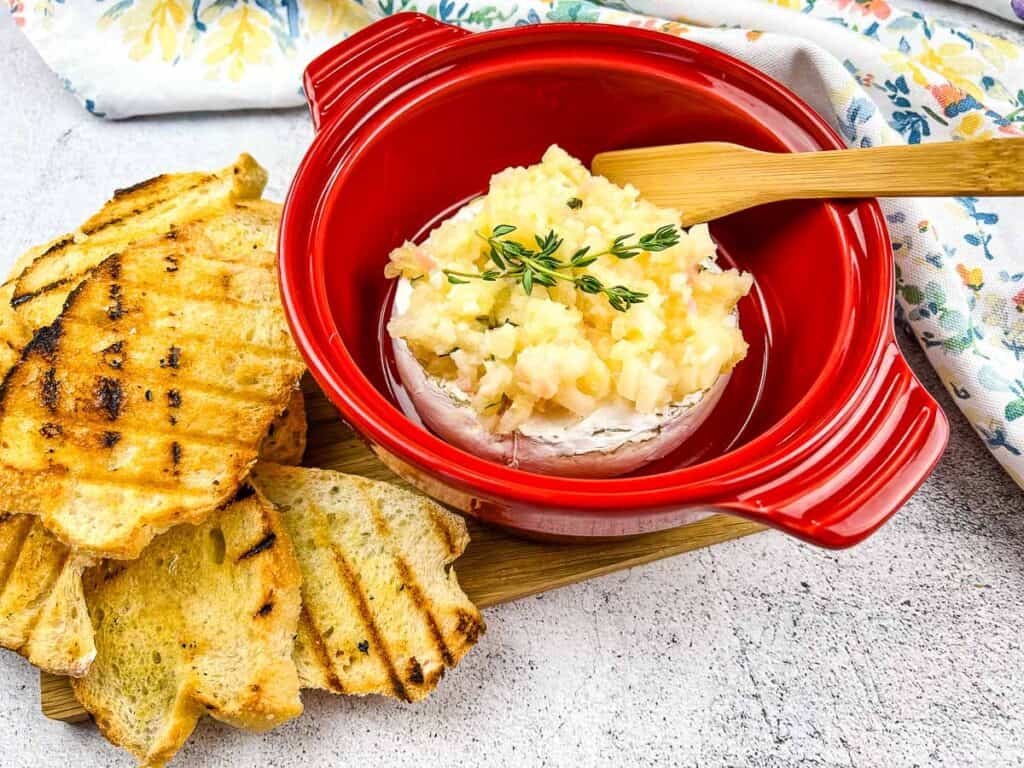 Baked brie with apple ginger chutney in a red brie baker.