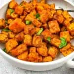 Air fryer sweet potato cubes in a white serving dish.