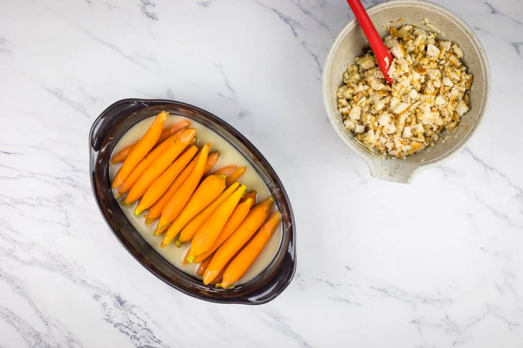 Parboiled carrots in the sauce in a baking dish.