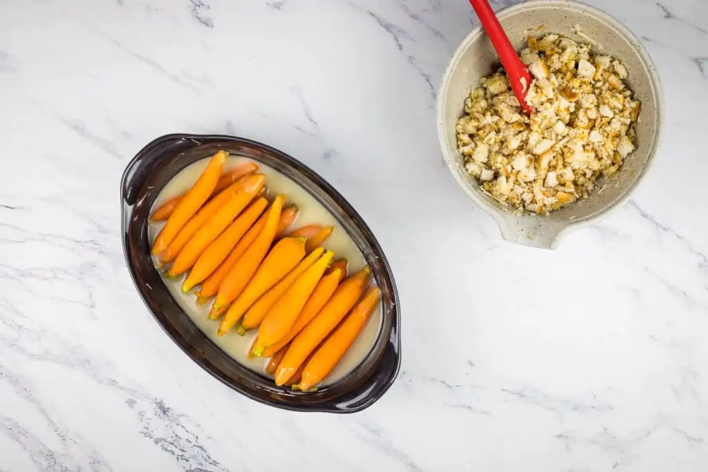 Parboiled carrots in the sauce in a baking dish.