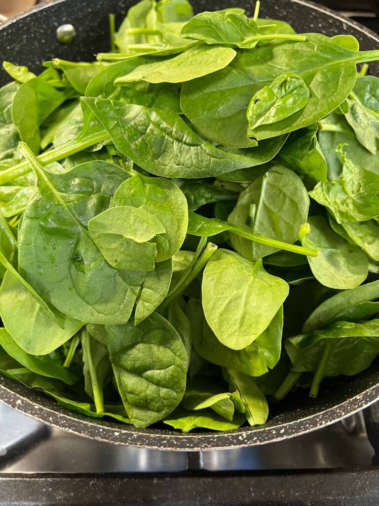 Fresh baby spinach in a skillet.