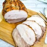 Sliced turkey roll roast on a cutting board.