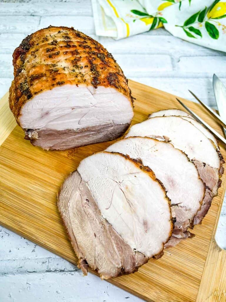 Sliced turkey roll roast on a cutting board.
