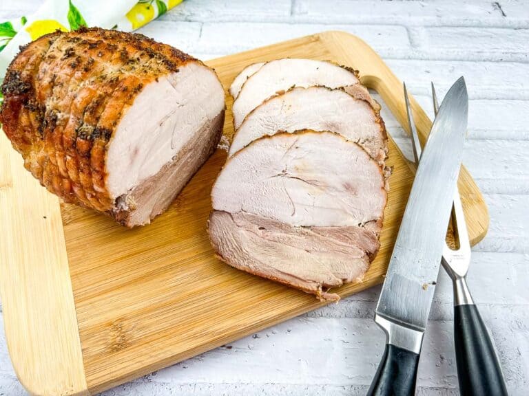 A top-down shot of sliced turkey roll on a cutting board.