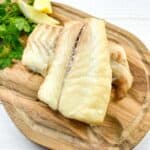 Smoked Cod on a cutting board with lemon and parsley.