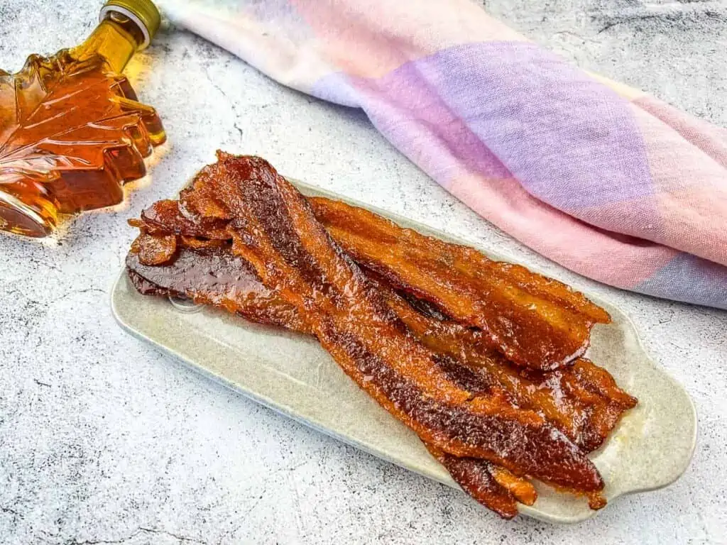 Smoked candied bacon on a white plate.